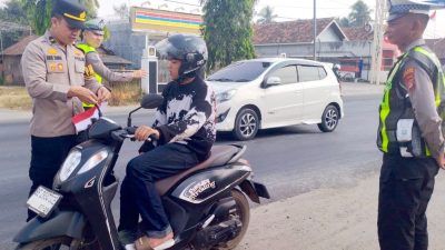 Polisi di Lampung Tengah Bagikan Ratusan Bendera Merah Putih Kepada Masyarakat Pengguna Jalan